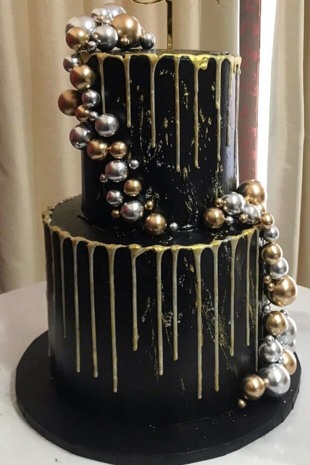 Luxurious black and gold wedding cake with golden dripping effect and silver beads
