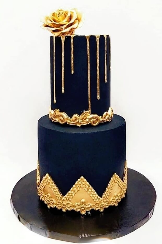 Stunning black and gold wedding cake with golden rose on black and gold plate