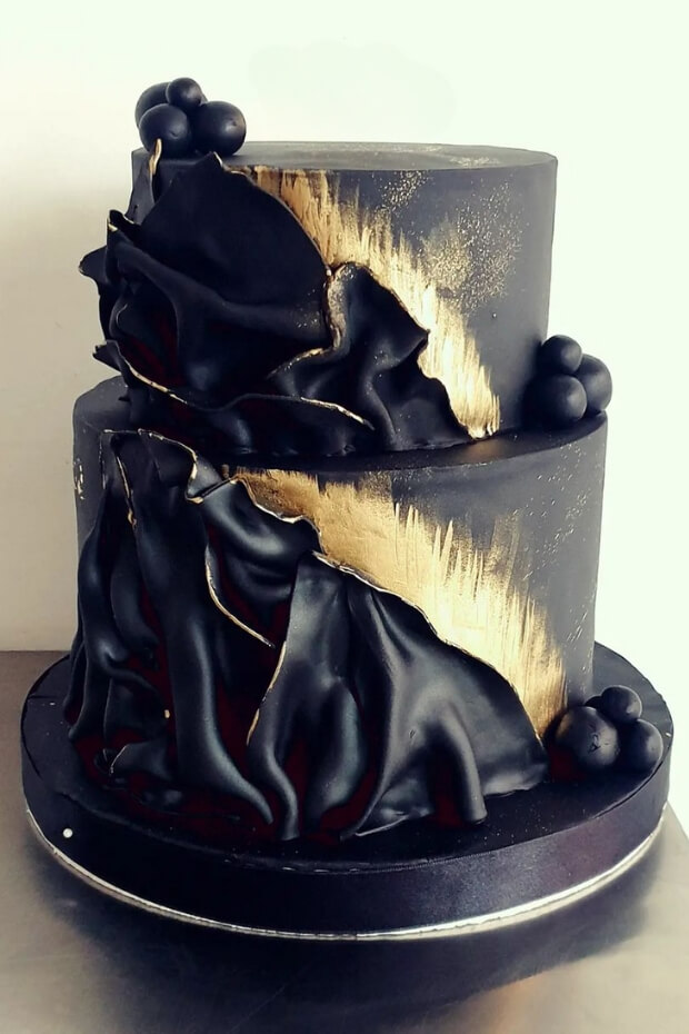 Sophisticated black and gold wedding cake with intricate design elements