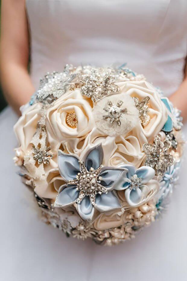 Bride holding blue and white flower bouquet