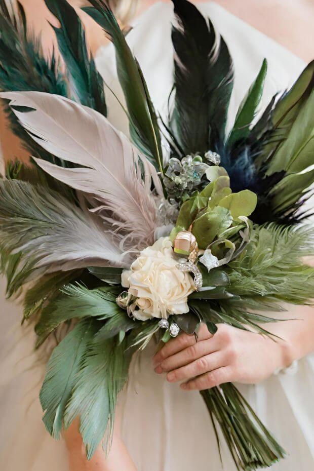 Bride holding green and white feather bouquet