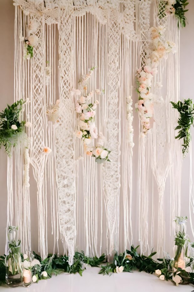 Elegant white lace wedding backdrop with greenery