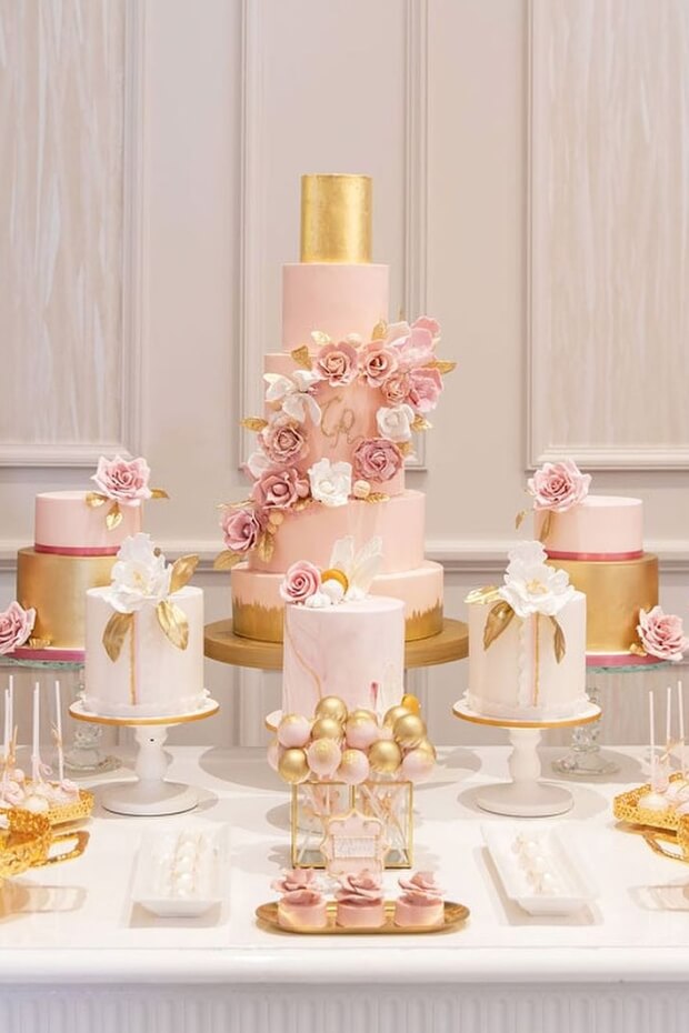 Decorated wedding cake and dessert table with pink and gold accents