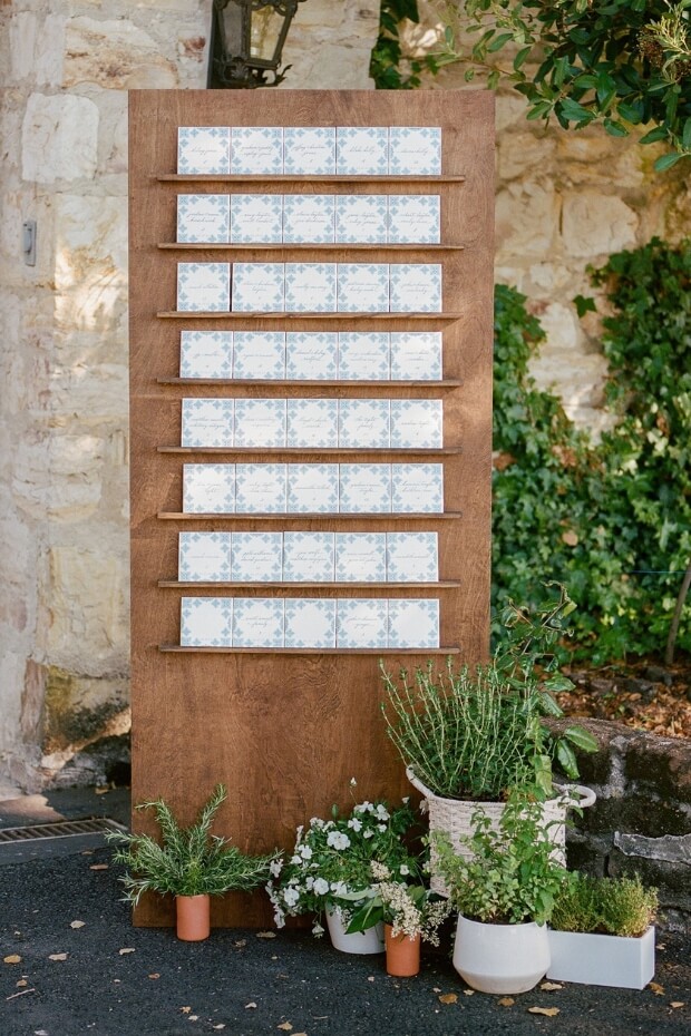 Rustic wooden wedding seating chart with potted plants