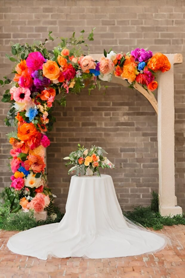 Rustic wooden wedding arch with oversized vibrant flowers