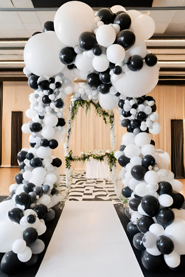 Beautiful wedding arch decorated with numerous black and white balloons