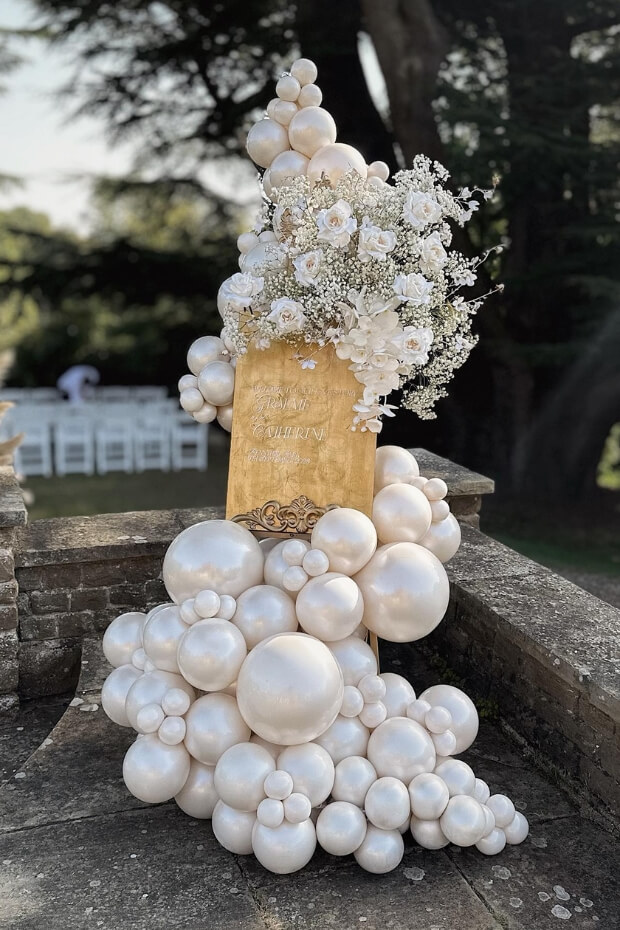 Wedding decoration setup with white balloons on stand