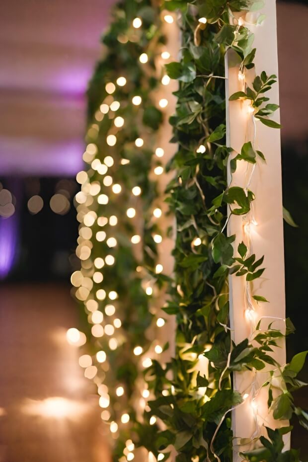 Wedding pillars adorned with fairy lights and greenery.