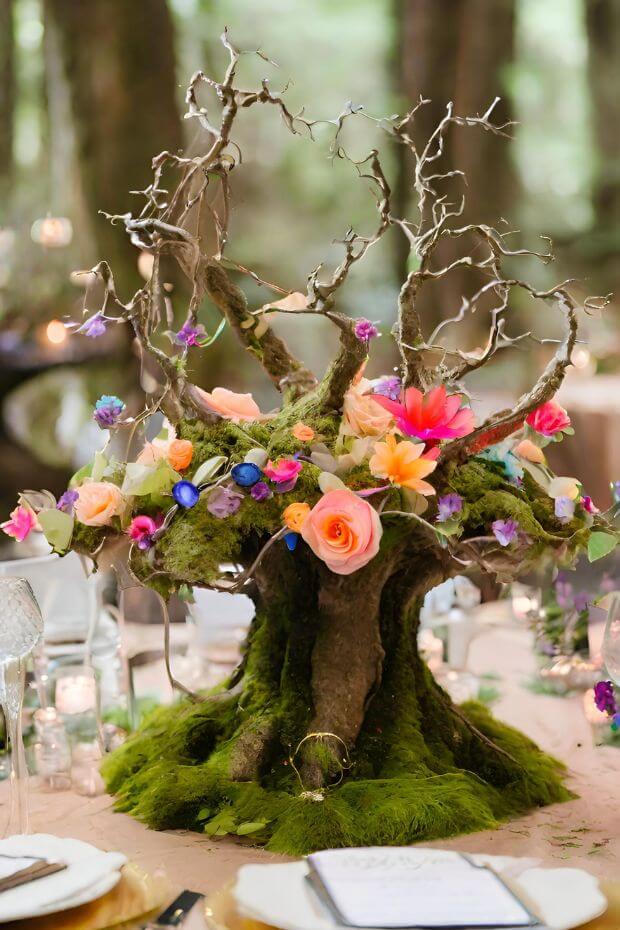 Mossy tree trunk centerpiece with colorful flowers and foliage