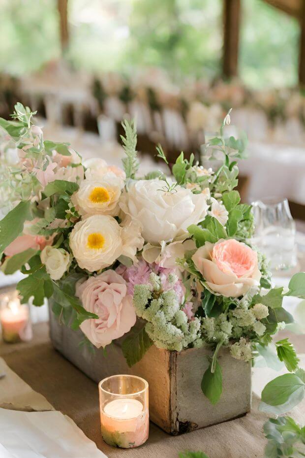 Vintage-inspired wooden crate centerpiece with various flowers and greens