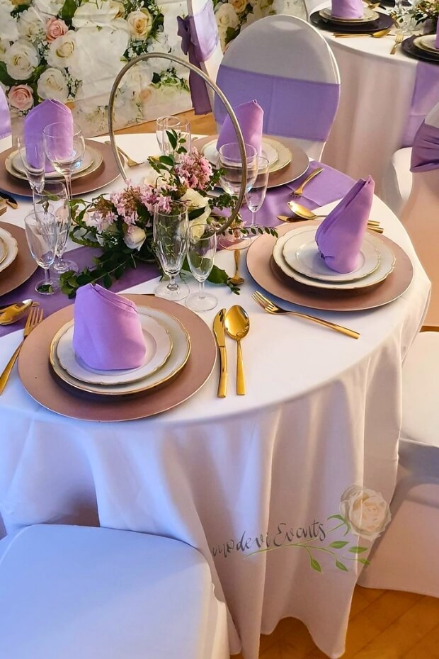 Elegant purple and gold table setting with gold-rimmed plates and purple napkins