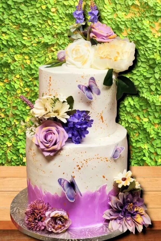 Elegant wedding cake adorned with purple and gold butterflies