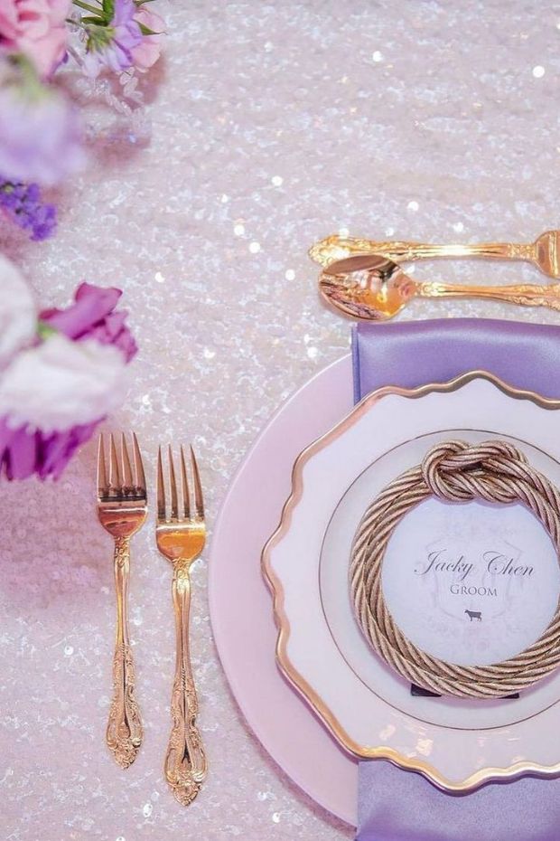Elegant dining table with lace tablecloth and purple and gold place settings