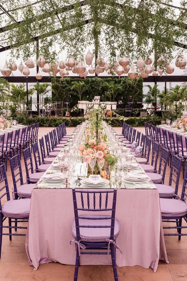 Outdoor purple wedding setup with long dining table