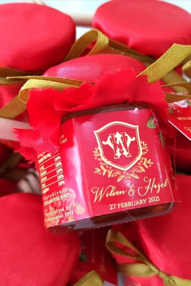 Red wedding theme favors with ribbons and glass bottle