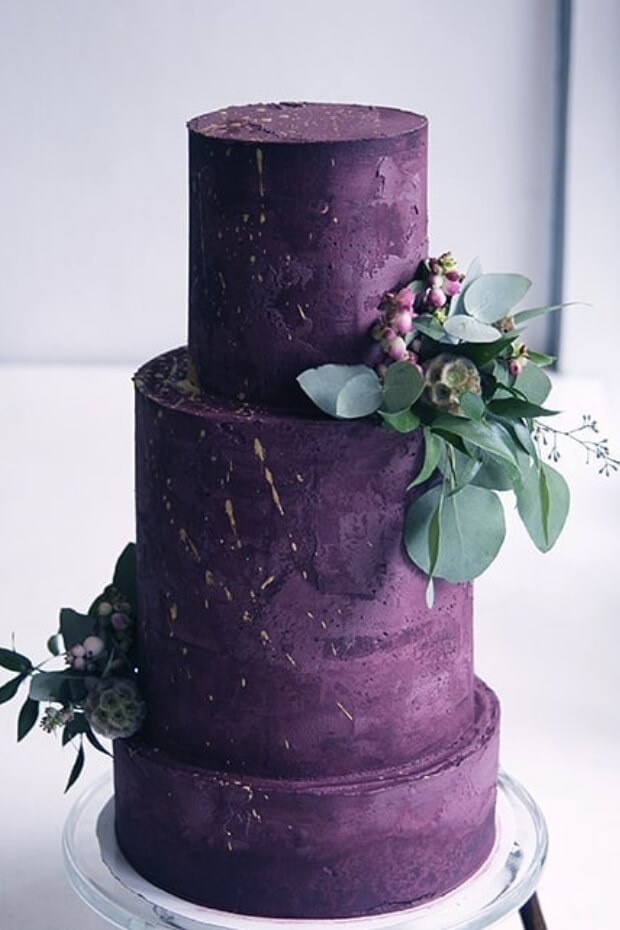 Stunning purple wedding cake with green foliage