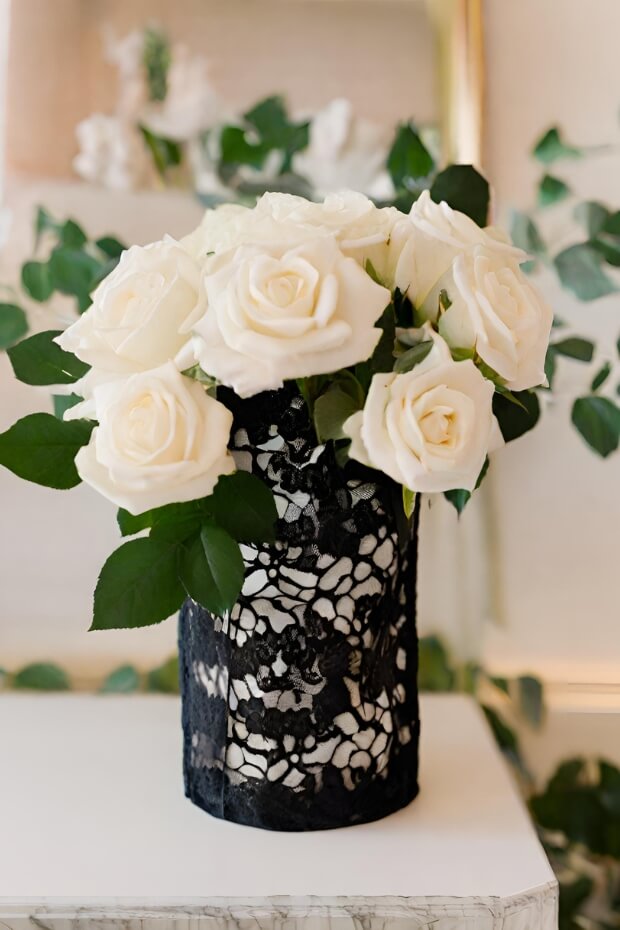 White rose centerpiece with lace cover on marble surface