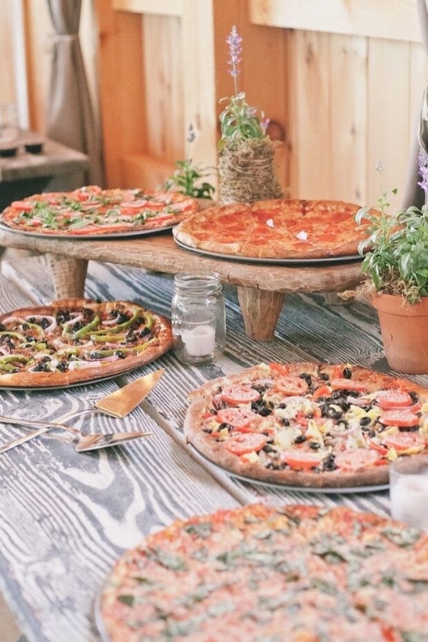 Wooden table with assorted pizzas