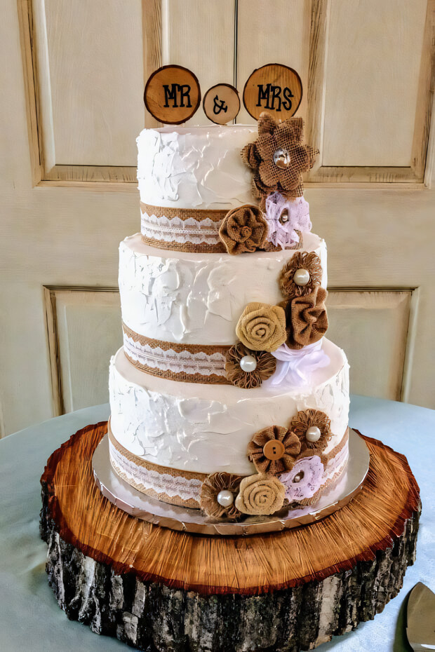 Rustic burlap-themed wedding cake on wooden slab
