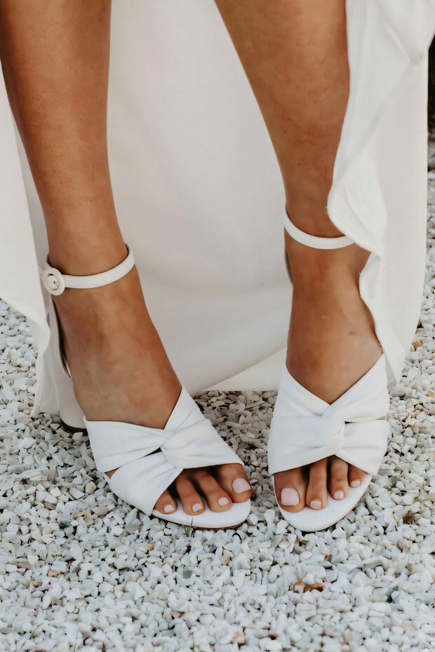 White boho wedding shoes with a bow detail.
