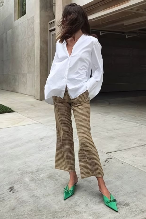 White shirt, tan cropped flare pants, emerald bow heels for a nice combo at a casual wedding