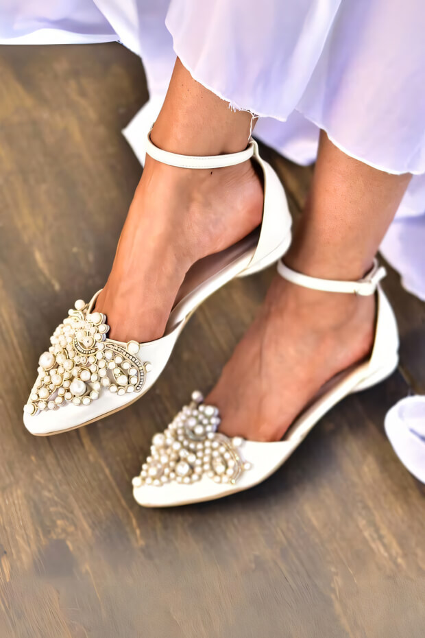 White shoes with pearl embellishments on toe and ankle, flat heel, and comfortable for the bride.