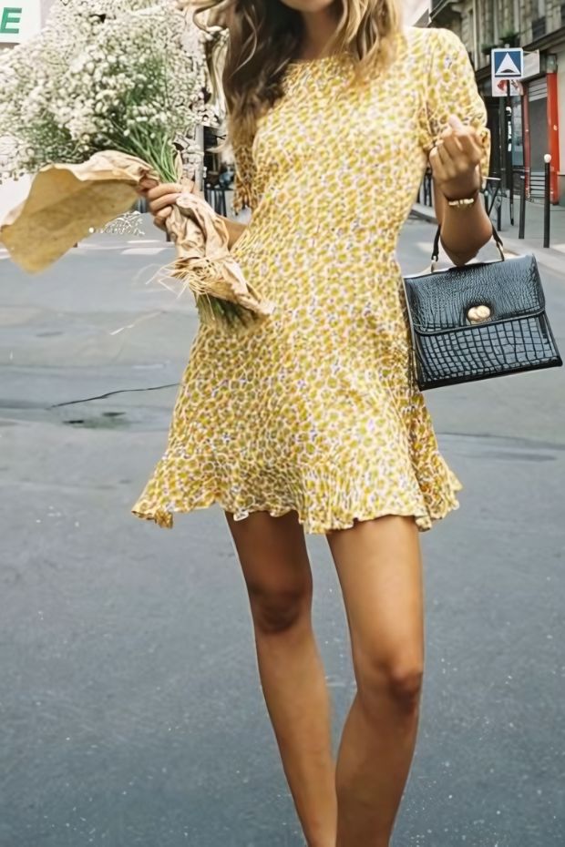 Yellow floral A-line mini dress with a high neckline, short sleeves, and a mini black bag