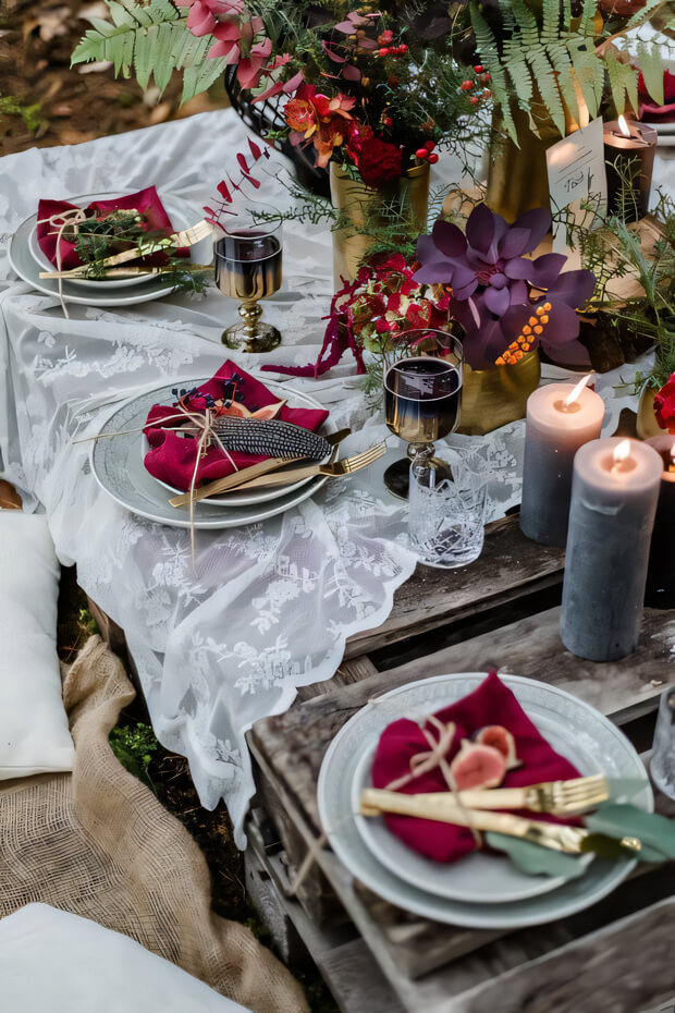 Bold enchanted forest wedding table setting with lace runner, dark and bright blooms