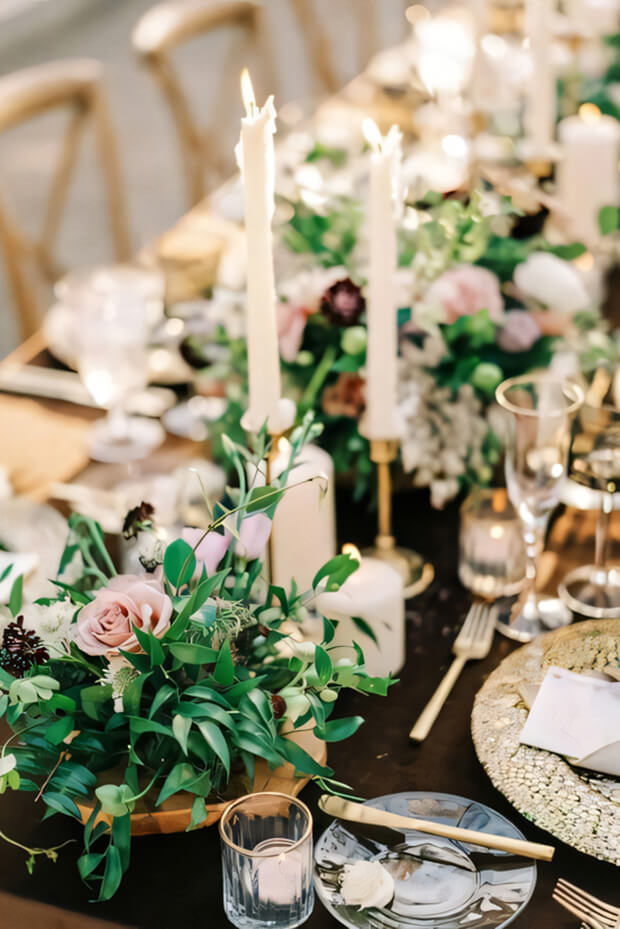 Enchanted forest wedding table setting with greenery, pink blooms