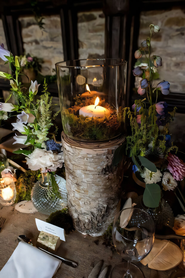 Enchanted forest wedding tablescape with tree stump candleholder, wildflowers
