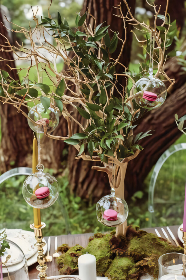 Fantastic enchanted forest wedding centerpiece with tree, greenery, pink macarons