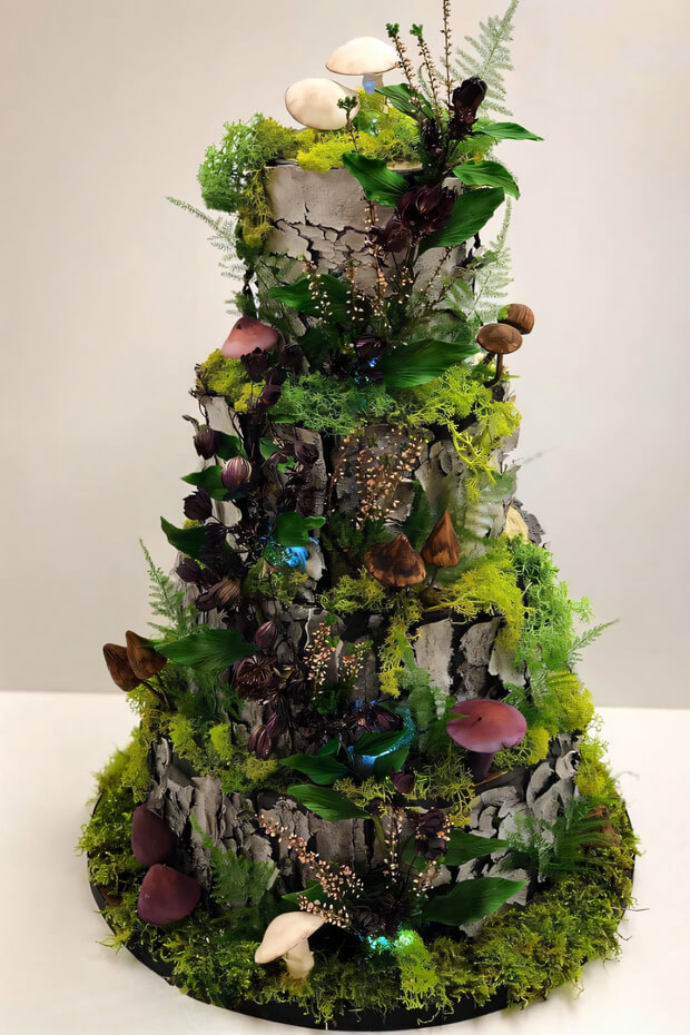 Moss-covered tree stump cake with ferns