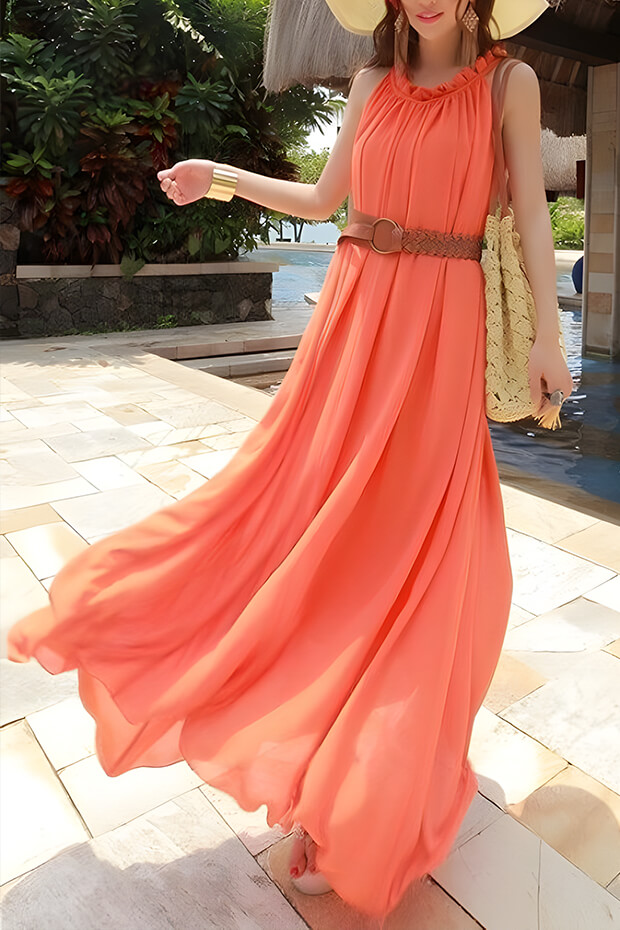 Orange A-line pleated maxi dress with brown belt and straw bag