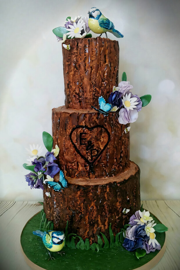 Tree stump cake adorned with purple and blue